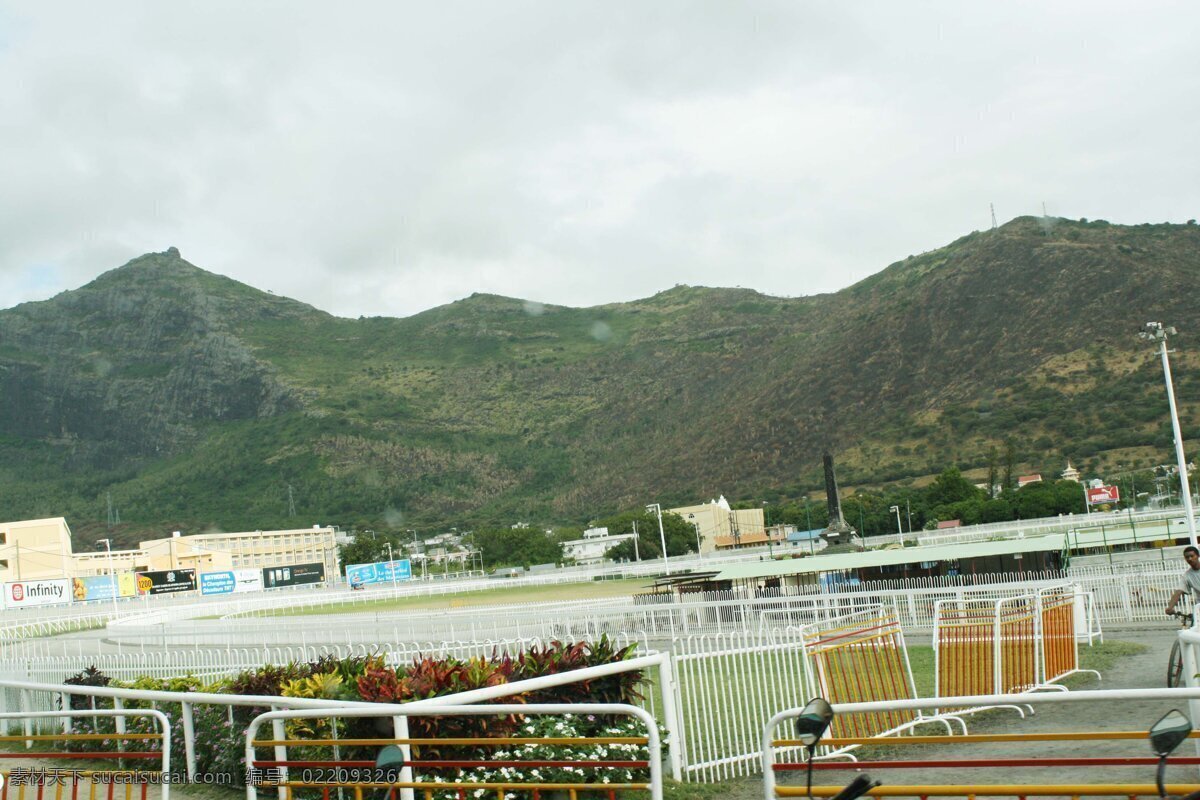 草地 大山 房屋 国外旅游 花草 活动栏 景点 景观 毛里求斯 路易港 旧赛马场 赛马场 环形赛道 白色护栏 赛场灯杆 赛场强光灯 烟囱式点火台 周围 商业广告牌 其他建筑 树林 犹如屏障 天空 白云遮天 印度洋岛国 旅游胜地 南印度洋島國 毛里求斯風光 旅游摄影 矢量图